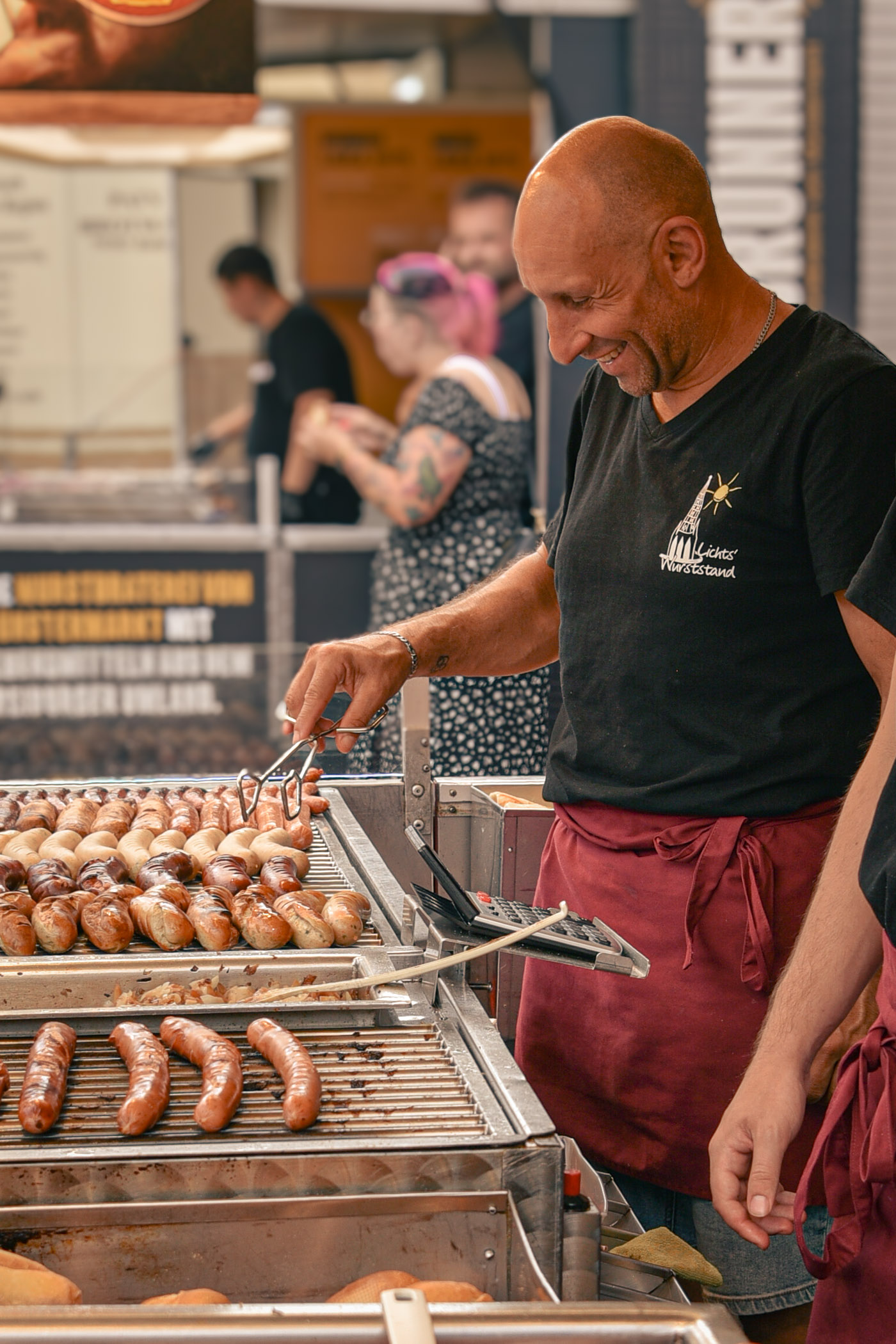 Mitarbeiter am Grill mit Bratwürsten